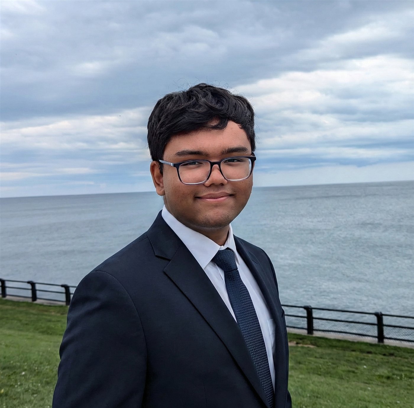 Alvik Maharjan in a navy suit by the waterfront